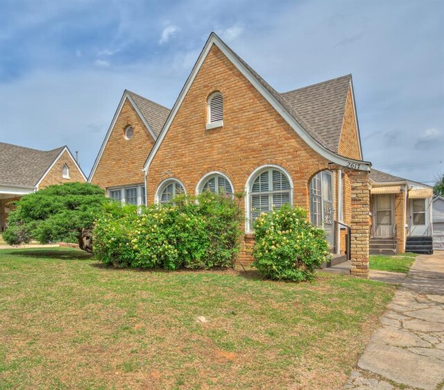 2617 NW 23rd St, Oklahoma City, OK 73107 - tudor house with brick siding, a front lawn, and roof with shingles