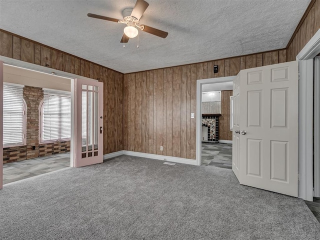 2617 NW 23rd St, Oklahoma City, OK 73107 - unfurnished room with wood walls, carpet floors, ceiling fan, and a textured ceiling