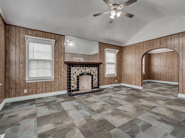 2617 NW 23rd St, Oklahoma City, OK 73107 - unfurnished living room with a ceiling fan, a fireplace, baseboards, wooden walls, and lofted ceiling