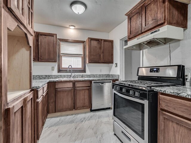 2617 NW 23rd St, Oklahoma City, OK 73107 - kitchen featuring appliances with stainless steel finishes, under cabinet range hood, a sink, light marble finish flooring, and light stone countertops