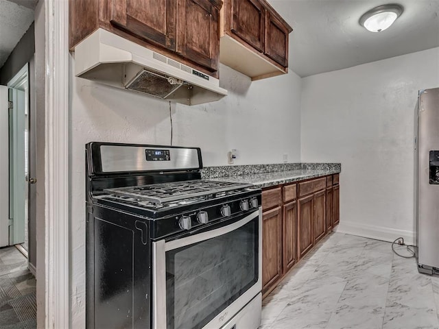 2617 NW 23rd St, Oklahoma City, OK 73107 - kitchen featuring stainless steel appliances, under cabinet range hood, light marble finish flooring, and baseboards