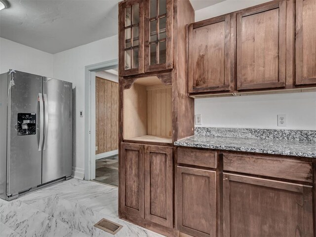 2617 NW 23rd St, Oklahoma City, OK 73107 - kitchen featuring stainless steel fridge with ice dispenser, light marble finish floors, glass insert cabinets, and light stone counters