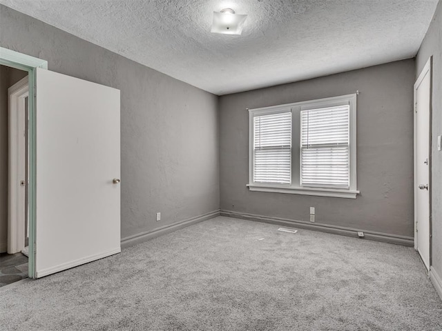 2617 NW 23rd St, Oklahoma City, OK 73107 - unfurnished bedroom featuring a textured ceiling, carpet flooring, baseboards, and a textured wall
