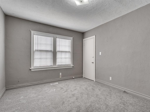 2617 NW 23rd St, Oklahoma City, OK 73107 - carpeted empty room featuring a textured ceiling and baseboards