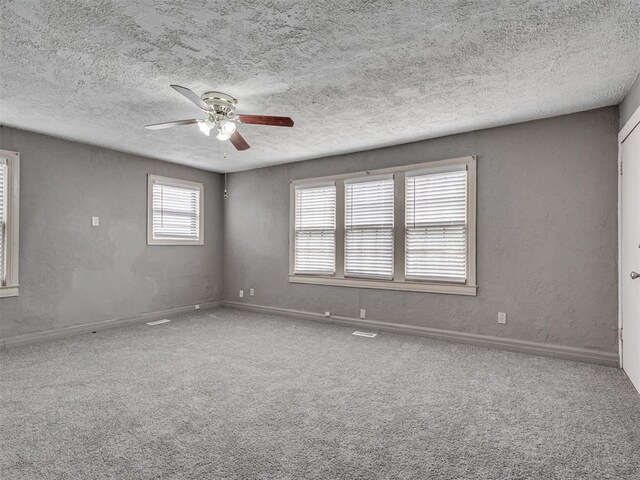 2617 NW 23rd St, Oklahoma City, OK 73107 - carpeted spare room featuring a ceiling fan, a textured ceiling, a textured wall, and baseboards