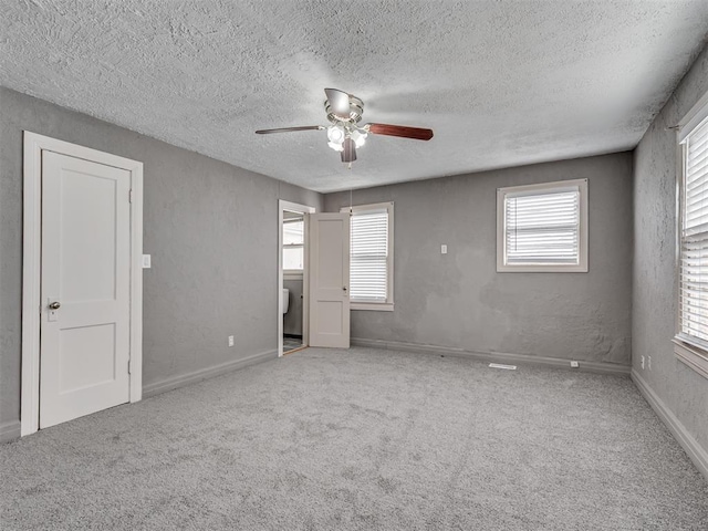2617 NW 23rd St, Oklahoma City, OK 73107 - unfurnished bedroom with a textured ceiling, carpet flooring, ceiling fan, a textured wall, and baseboards
