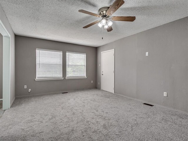 2617 NW 23rd St, Oklahoma City, OK 73107 - spare room with ceiling fan, a textured ceiling, and carpet flooring
