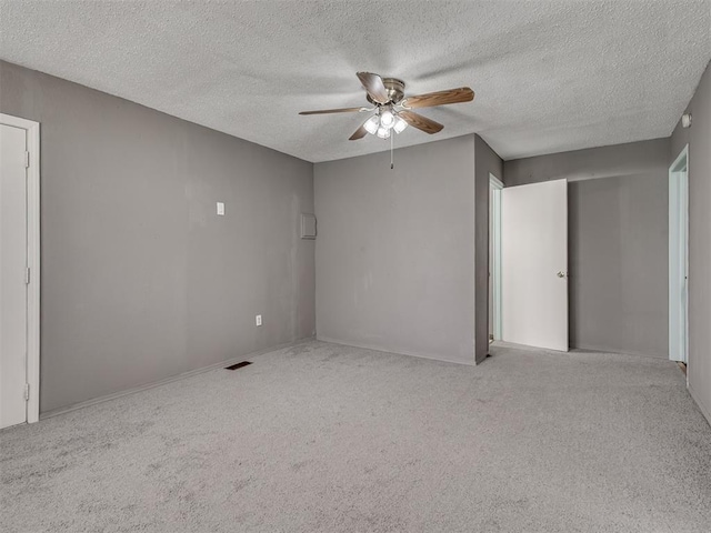 2617 NW 23rd St, Oklahoma City, OK 73107 - spare room with a ceiling fan, a textured ceiling, carpet floors, and baseboards