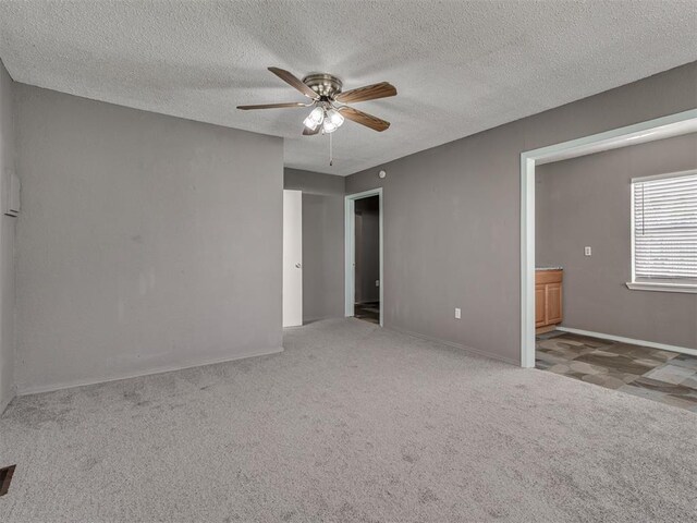 2617 NW 23rd St, Oklahoma City, OK 73107 - carpeted spare room with ceiling fan, a textured ceiling, and baseboards