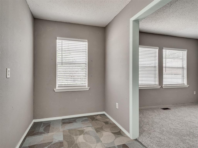 2617 NW 23rd St, Oklahoma City, OK 73107 - carpeted spare room featuring a textured ceiling, plenty of natural light, and baseboards