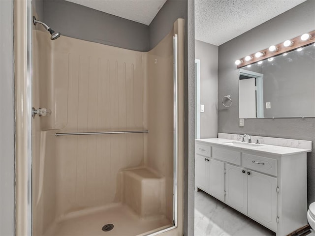 2617 NW 23rd St, Oklahoma City, OK 73107 - full bathroom featuring a shower stall, vanity, a textured ceiling, and toilet