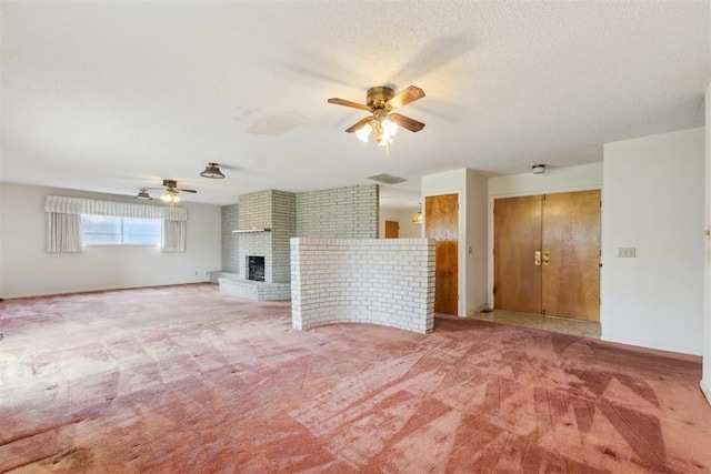 1009 Cherokee Pl, Lindsay, OK 73052 - unfurnished living room featuring a ceiling fan, light carpet, a fireplace, and a textured ceiling