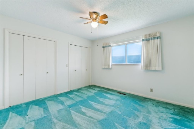 1009 Cherokee Pl, Lindsay, OK 73052 - unfurnished bedroom with multiple closets, carpet floors, a textured ceiling, baseboards, and ceiling fan
