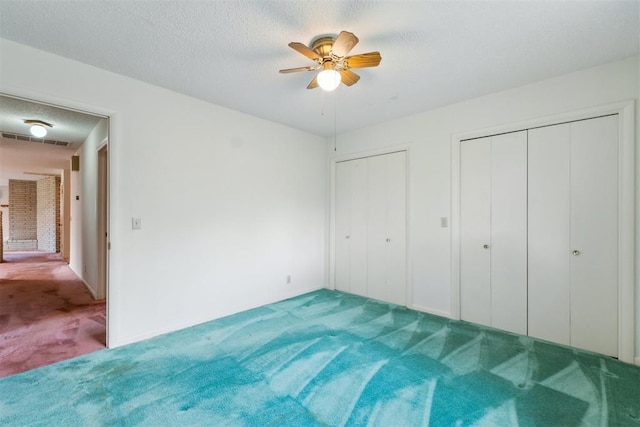 1009 Cherokee Pl, Lindsay, OK 73052 - unfurnished bedroom with carpet flooring, multiple closets, ceiling fan, and a textured ceiling