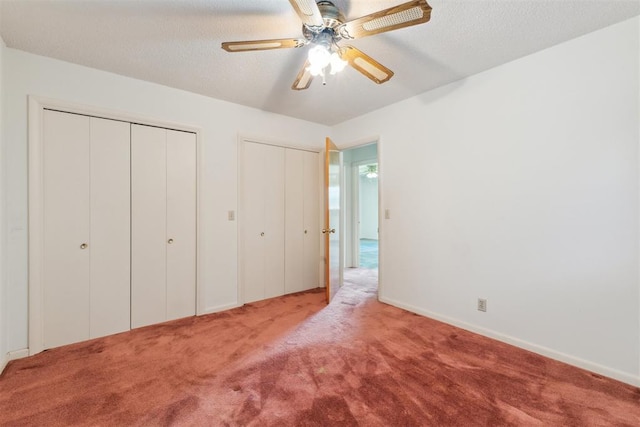 1009 Cherokee Pl, Lindsay, OK 73052 - unfurnished bedroom featuring two closets, carpet flooring, ceiling fan, baseboards, and a textured ceiling