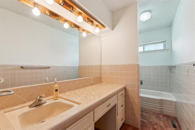 1009 Cherokee Pl, Lindsay, OK 73052 - bathroom with tile walls, a garden tub, vanity, and a wainscoted wall