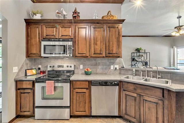 8701 Long Spur Trl, Edmond, OK 73034 - kitchen with appliances with stainless steel finishes, a sink, ceiling fan, backsplash, and a peninsula