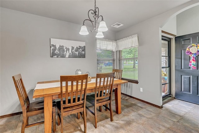 8701 Long Spur Trl, Edmond, OK 73034 - dining space with arched walkways, a chandelier, and baseboards