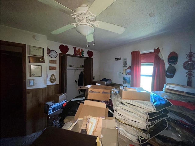 811 N Admire Ave, El Reno, OK 73036 - bedroom with a textured ceiling, a wainscoted wall, ceiling fan, and wood walls