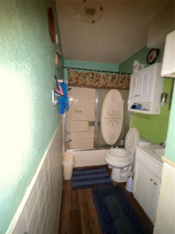 811 N Admire Ave, El Reno, OK 73036 - bathroom with tile walls, toilet, vanity, wood finished floors, and a wainscoted wall