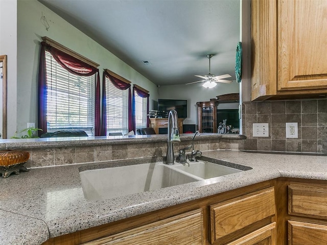 9315 Fendrych Dr, Oklahoma City, OK 73165 - kitchen with a sink, tasteful backsplash, a ceiling fan, and light stone countertops