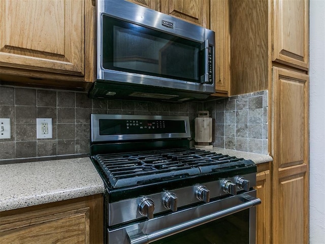 9315 Fendrych Dr, Oklahoma City, OK 73165 - kitchen featuring stainless steel appliances, tasteful backsplash, light stone countertops, and brown cabinetry