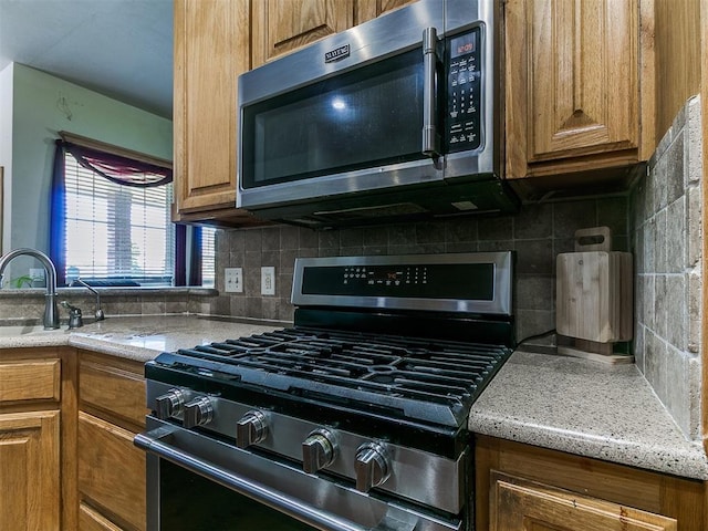 9315 Fendrych Dr, Oklahoma City, OK 73165 - kitchen featuring stainless steel appliances, brown cabinetry, and a sink