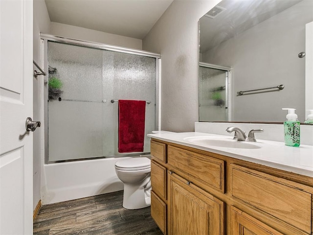 9315 Fendrych Dr, Oklahoma City, OK 73165 - full bathroom with wood finished floors, vanity, toilet, and combined bath / shower with glass door