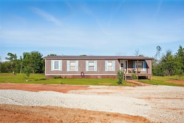 manufactured / mobile home featuring covered porch and a front lawn