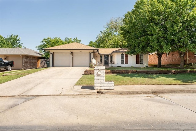ranch-style home featuring a garage, driveway, and a front yard
