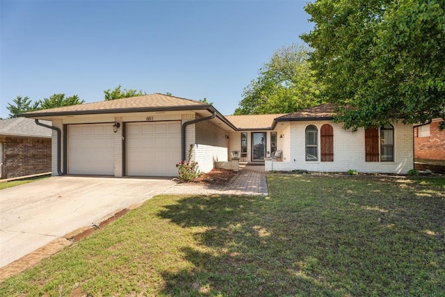single story home featuring brick siding, a garage, driveway, and a front lawn