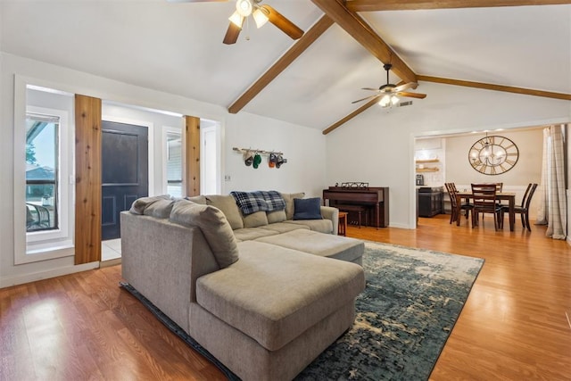 living room featuring a ceiling fan, wood finished floors, and a chandelier