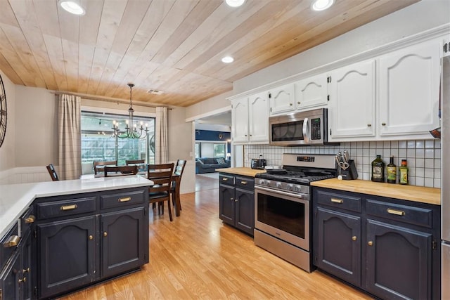 kitchen with appliances with stainless steel finishes, white cabinetry, a chandelier, recessed lighting, and light wood-style floors
