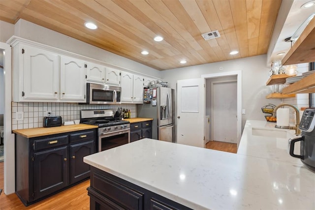 kitchen with stainless steel appliances, white cabinetry, a sink, wood ceiling, and recessed lighting