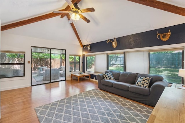 living room with beam ceiling, plenty of natural light, wood finished floors, a ceiling fan, and baseboards