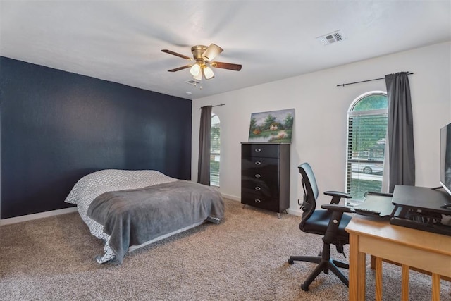carpeted bedroom featuring an office area, baseboards, and ceiling fan