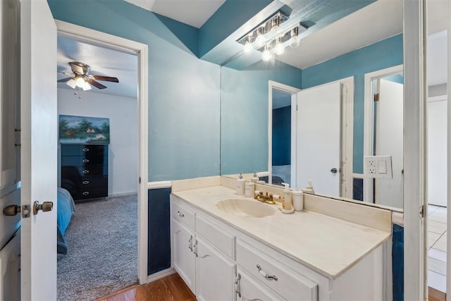 ensuite bathroom with vanity, ceiling fan, and wood finished floors