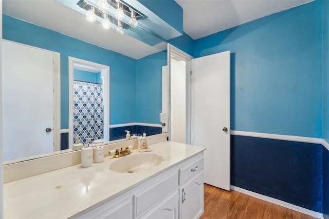 full bath featuring wood finished floors, vanity, and curtained shower