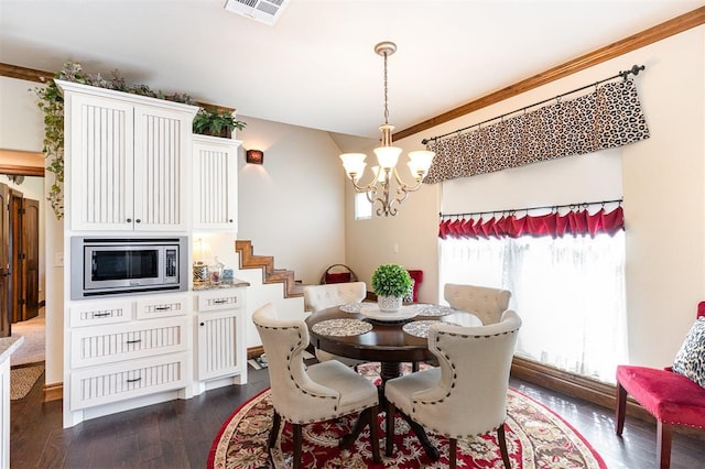 dining space featuring a chandelier, dark wood-style floors, crown molding, and stairway