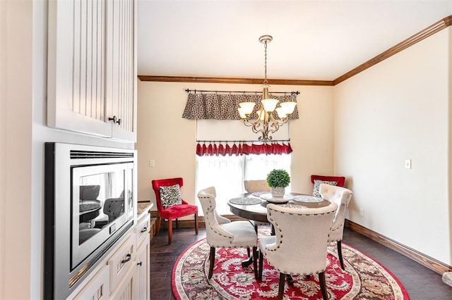 dining space with a chandelier, ornamental molding, dark wood finished floors, baseboards, and a large fireplace