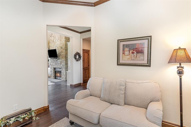 living area featuring ornamental molding, baseboards, dark wood-style flooring, and a fireplace
