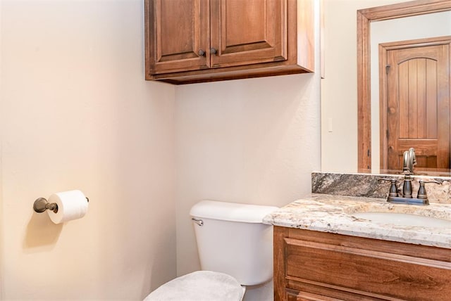 half bath featuring toilet and vanity