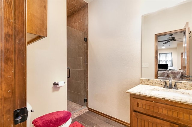 full bath with a shower stall, vanity, a ceiling fan, baseboards, and wood finished floors