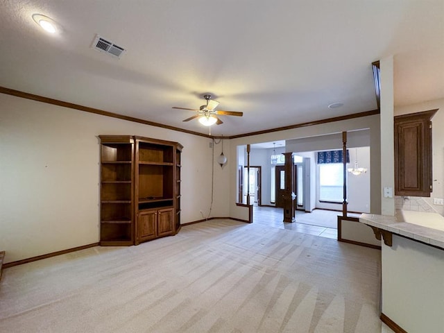 3424 Teton Ct, Norman, OK 73072 - unfurnished living room featuring baseboards, ornamental molding, a ceiling fan, and light colored carpet