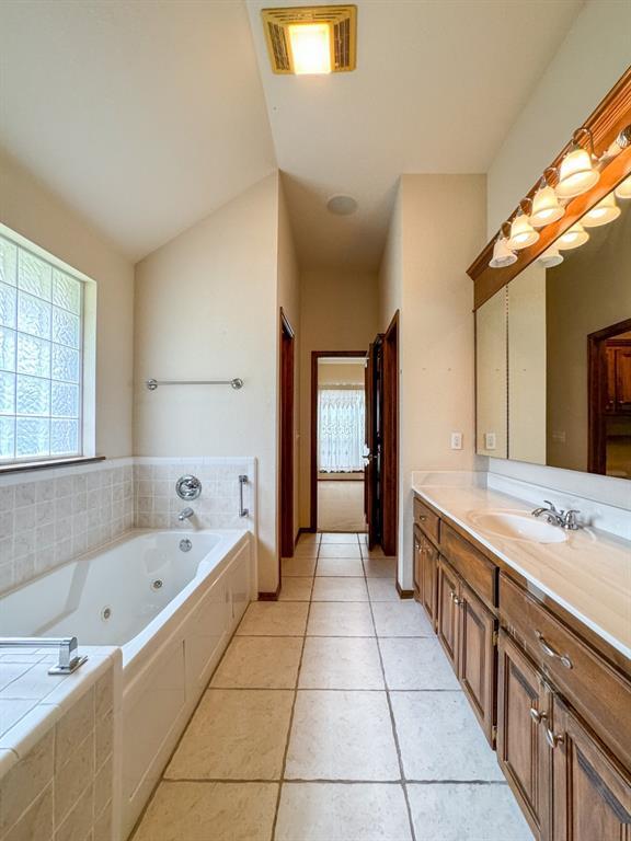 3424 Teton Ct, Norman, OK 73072 - bathroom featuring vanity, a jetted tub, healthy amount of natural light, and tile patterned flooring
