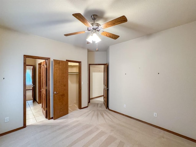 3424 Teton Ct, Norman, OK 73072 - unfurnished bedroom featuring a walk in closet, light carpet, a closet, baseboards, and ceiling fan