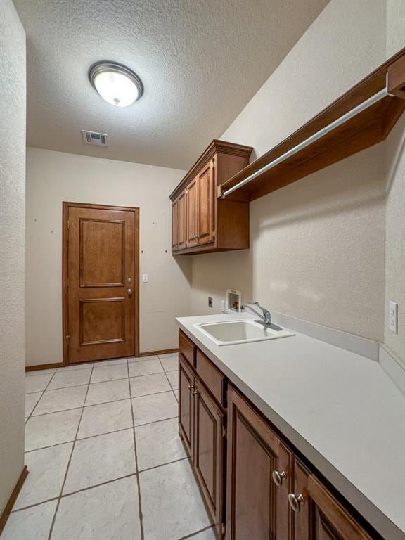 3424 Teton Ct, Norman, OK 73072 - laundry room featuring washer hookup, electric dryer hookup, a textured ceiling, baseboards, and light tile patterned flooring