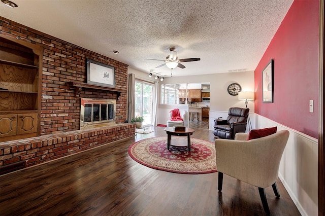 5708 NW 87th St, Oklahoma City, OK 73132 - living room featuring a textured ceiling, a brick fireplace, wood finished floors, a ceiling fan, and built in features