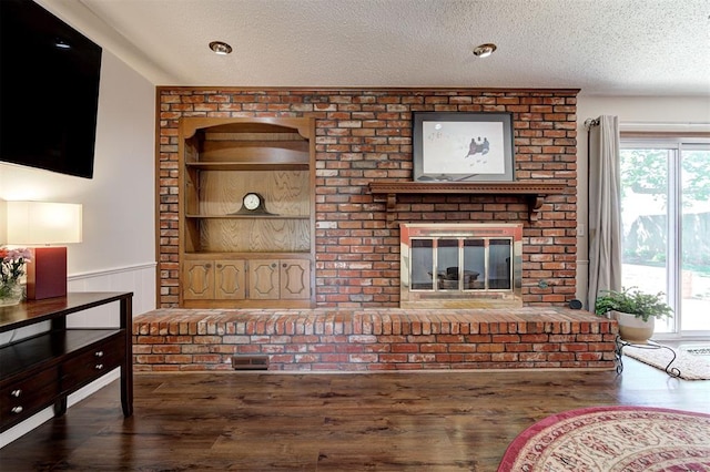 5708 NW 87th St, Oklahoma City, OK 73132 - unfurnished living room featuring wood finished floors, a wainscoted wall, a textured ceiling, and a fireplace