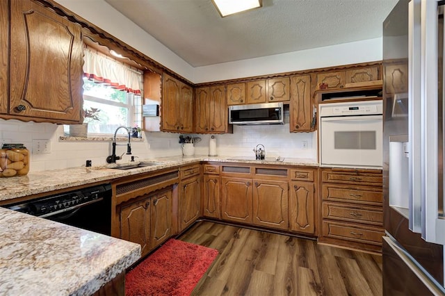 5708 NW 87th St, Oklahoma City, OK 73132 - kitchen with black appliances, a sink, brown cabinets, and dark wood-style floors